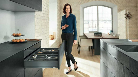 Woman standing in a modern kitchen with black appliances